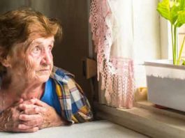 Old woman looking through window